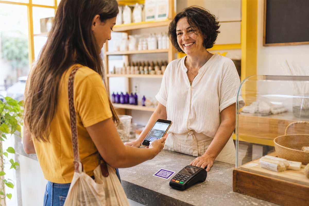 Cliente escaneando QR Code no balcão de uma loja